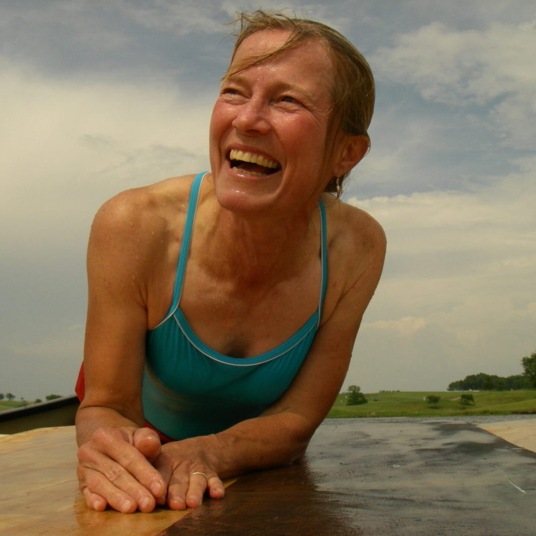 A woman laughing while lying on the ground.